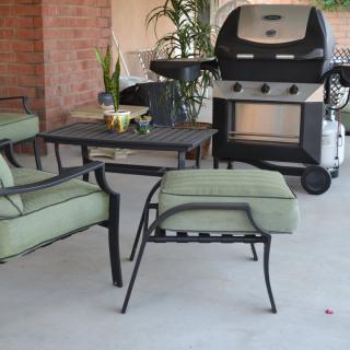 Outdoor patio setup with seating and a grill.