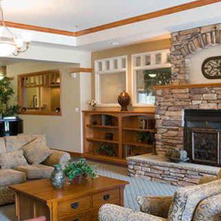 A cozy living room featuring a stone fireplace, comfortable seating, and wood accents.
