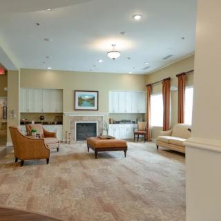 A spacious living room with elegant furnishings, featuring a fireplace and ample natural light.