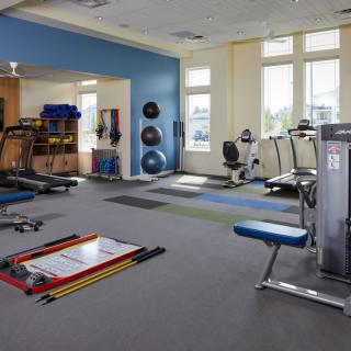 A spacious gym filled with various exercise equipment and workout areas.