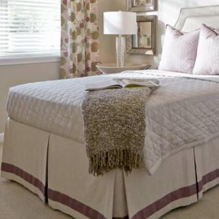 A cozy bedroom with a neatly made bed and decorative elements.