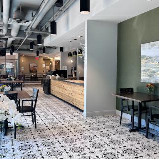 A modern restaurant interior featuring stylish furniture and patterned tile flooring.