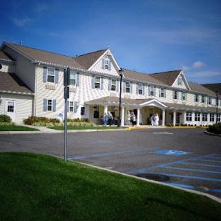 A sunny day view of a residential healthcare facility with landscaped grounds.