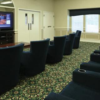 A small theater room with comfortable seating and a TV screen.