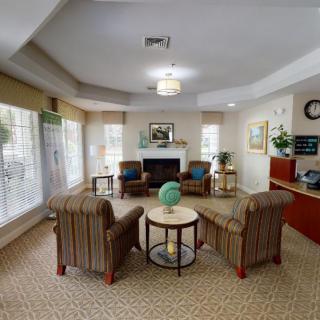 A cozy living room with a fireplace, comfortable chairs, and tasteful decor.
