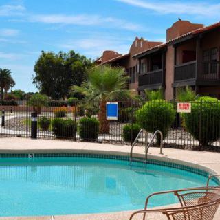 A tranquil swimming pool in a residential apartment complex on a sunny day.