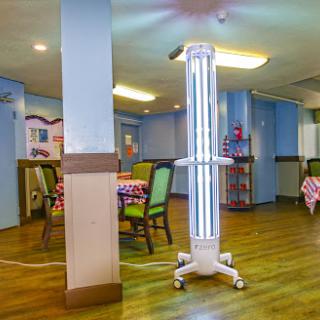 A UV disinfection lamp set up in a dining area to help maintain cleanliness and safety.