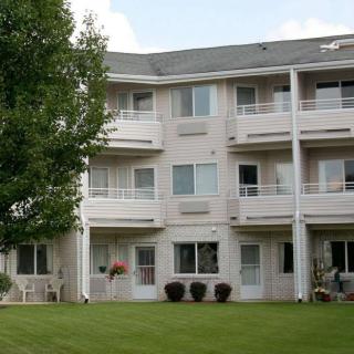 A view of a multi-story apartment building with balconies surrounded by greenery.