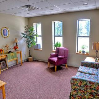 A cozy living room with comfortable seating and natural light from multiple windows.
