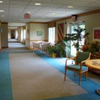 A well-lit hallway with seating areas and indoor plants.