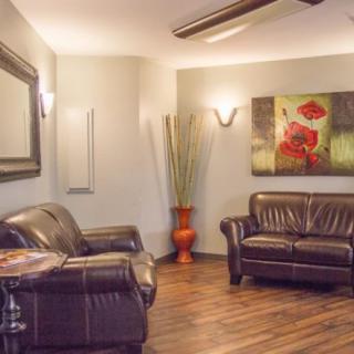 A cozy living room featuring leather sofas, modern decor, and a wooden floor.