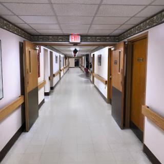 A perspective view of a long hallway with doors lining both sides.