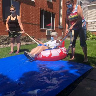 Group of people enjoy a summer day with tubing in the yard.