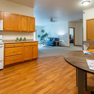 Open-concept kitchen and living room with wooden flooring.