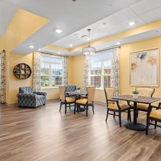 A bright and inviting lounge area featuring yellow walls, comfortable seating, and ample natural light.