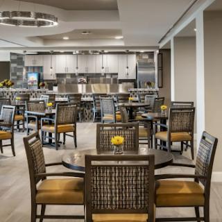 A modern dining area featuring stylish furniture and an open kitchen space.