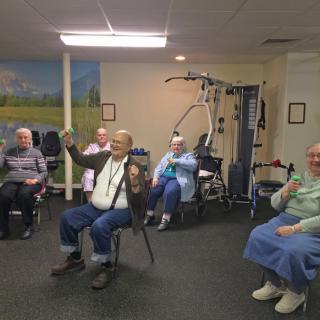Elderly individuals participating in a group exercise session indoors.