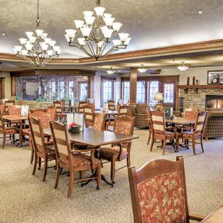 A cozy dining room with wooden furniture and elegant chandeliers.