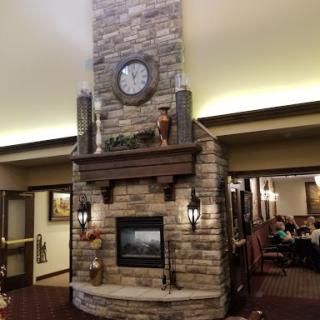 A beautifully designed stone fireplace with a wall clock, adding warmth and charm to the living space.