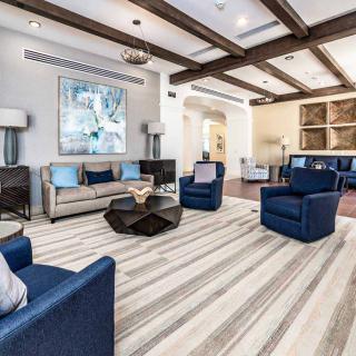 A modern living room with blue chairs, a beige sofa, and a stylish coffee table.