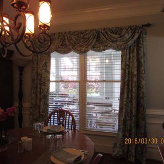 A cozy dining room with elegant curtains and a classic chandelier.