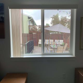 A view of a backyard patio with outdoor furniture seen through a window.