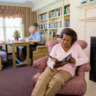 Elderly individuals enjoying a cozy reading space in a community library.