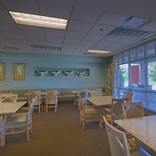 An empty restaurant dining area with tables and chairs arranged neatly.