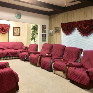 A cozy living room with red-covered sofas and matching curtains.
