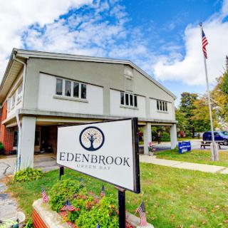 Edenbrook facility with a clear blue sky and American flag.