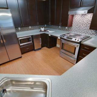 A modern kitchen featuring stainless steel appliances and wooden cabinets.