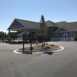A modern building with a driveway and landscaped entrance.