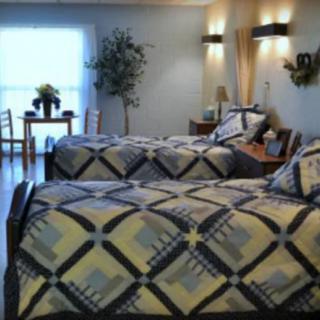A well-decorated bedroom featuring twin beds with quilted bedspreads and stylish interior design elements.