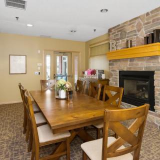A cozy dining room with a wooden table, chairs, and a fireplace.