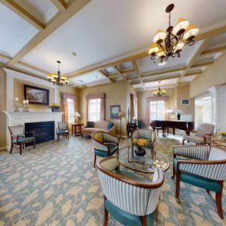 An elegant living room featuring a cozy seating area, a fireplace, and a grand piano.