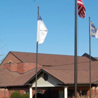 A church building with three flags flying in front.