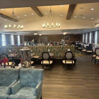 A spacious lounge and dining area with elegant chandeliers and comfortable seating.