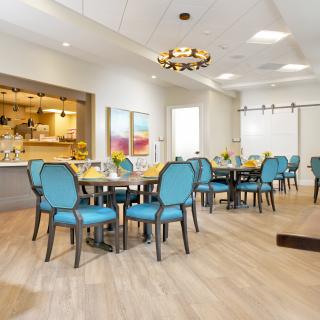 A modern dining area with blue chairs and neatly arranged tables.