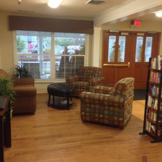 A cozy seating area in a lobby with comfortable chairs and a view through large windows.