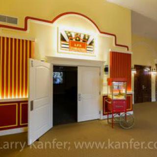 The interior of a classic movie theater with a popcorn machine near the entrance.