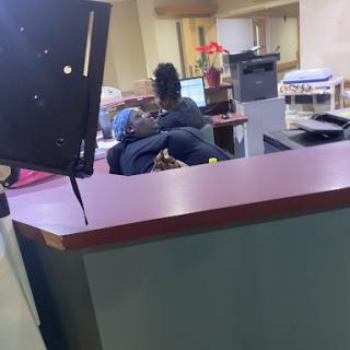Staff engaged in activities at a reception desk in an office environment.
