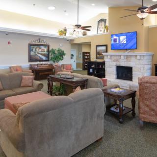 A cozy living room with comfortable seating, a fireplace, and a television.