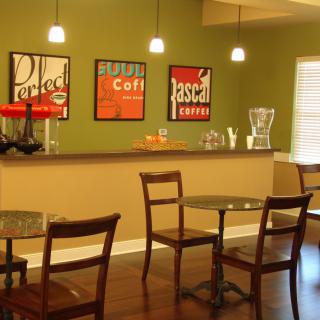 A modern cafe interior with tables, chairs, and contemporary artwork on the walls.