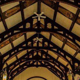 A detailed view of a church interior showcasing wooden beams and gothic architectural elements.