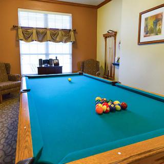 A cozy game room featuring a pool table with billiard balls set up for play.