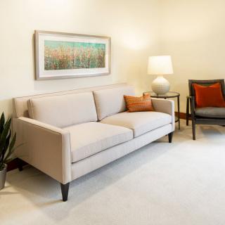 A modern living room with a beige sofa, an armchair, and stylish decor elements.