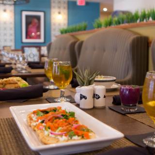 A beautifully set table in a cozy restaurant featuring an appetizing dish and refreshing drinks.