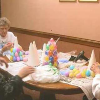 A group of people engaged in crafting colorful decorations around a table.