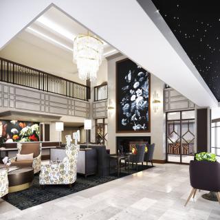 Modern and luxurious hotel lobby with elegant decor and a grand chandelier.