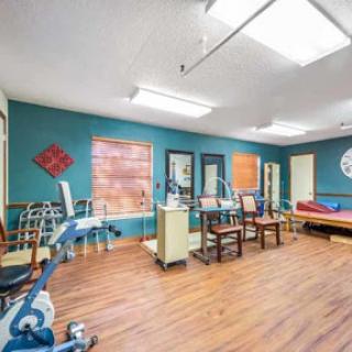 A bright and inviting therapy room equipped with exercise tools and a comfortable seating area.